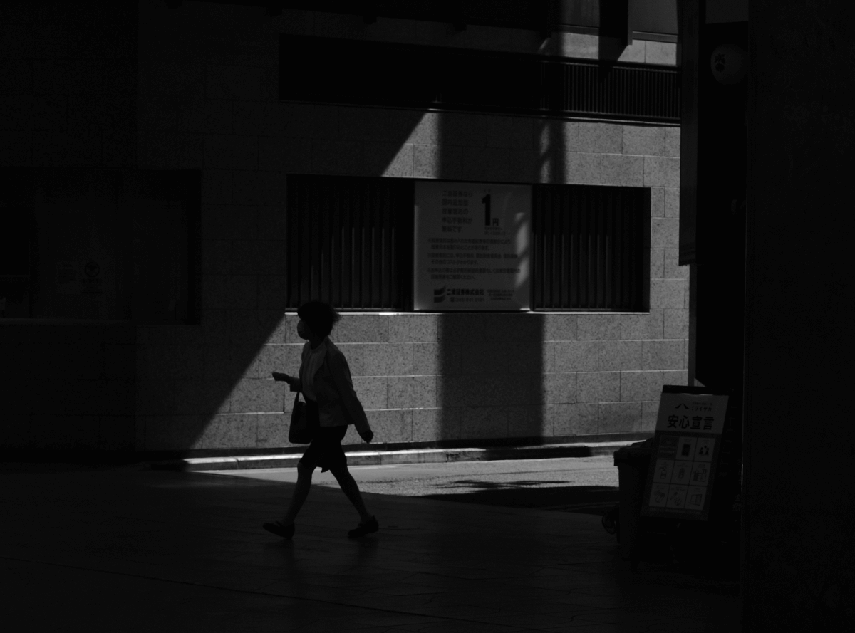 a-person-walking-down-a-street-in-the-dark-1200